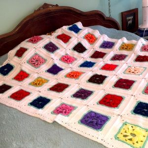 Vintage handcrafted Afghan throw 3-D granny squares on white.